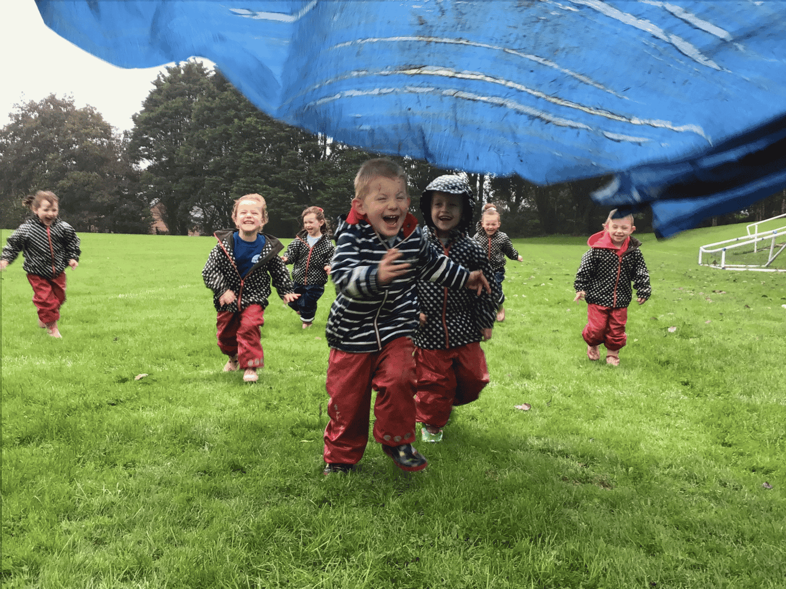 Wild Warrios Nursery Children outdoors with parachute