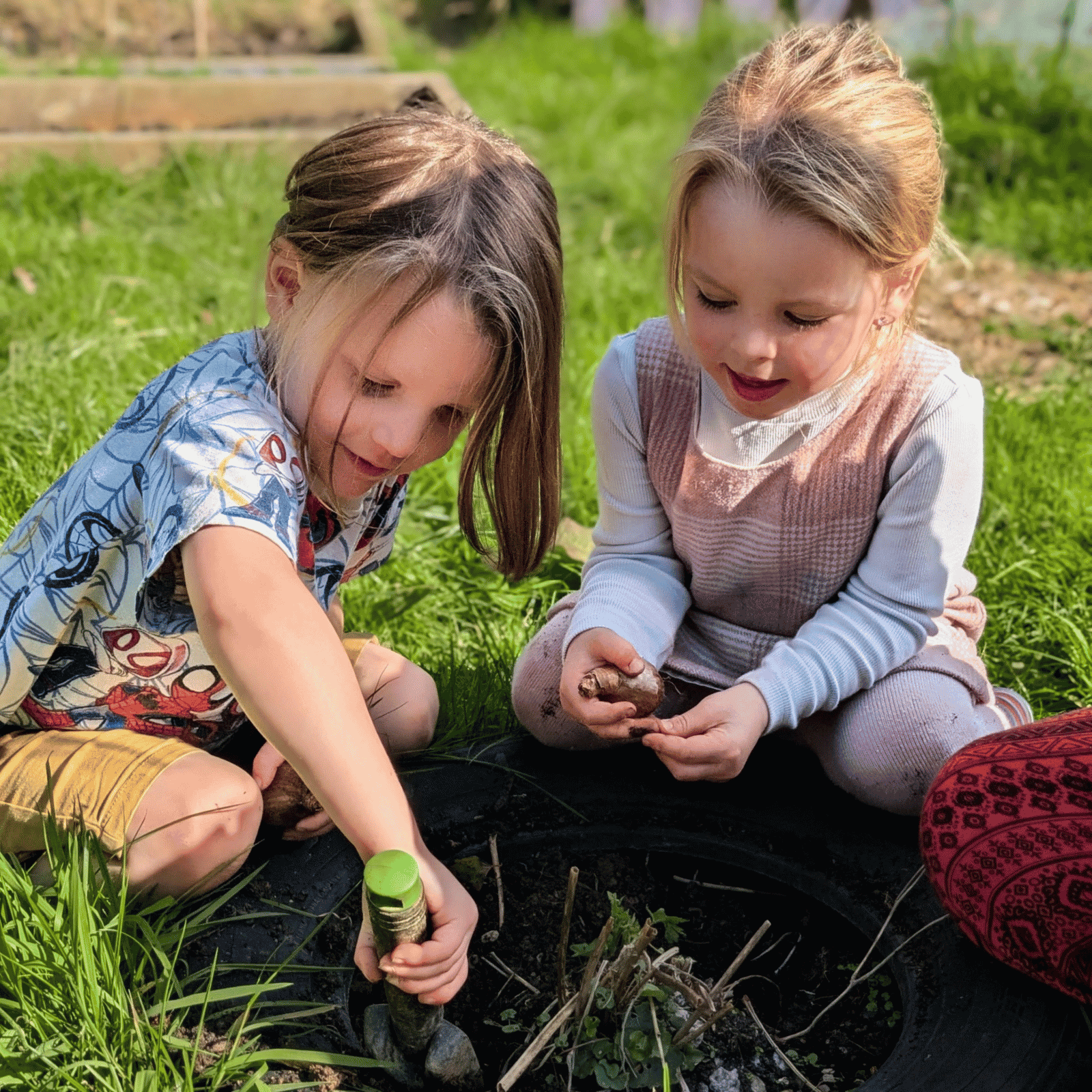 Wild Warrios Nursery Children planting a bulb outdoors