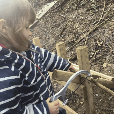 Burrows Nursery child using a saw